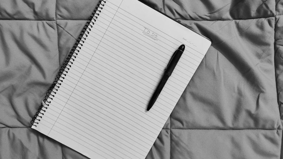 Caderno de planejamento semanal aberto sobre a mesa com caneta ao lado